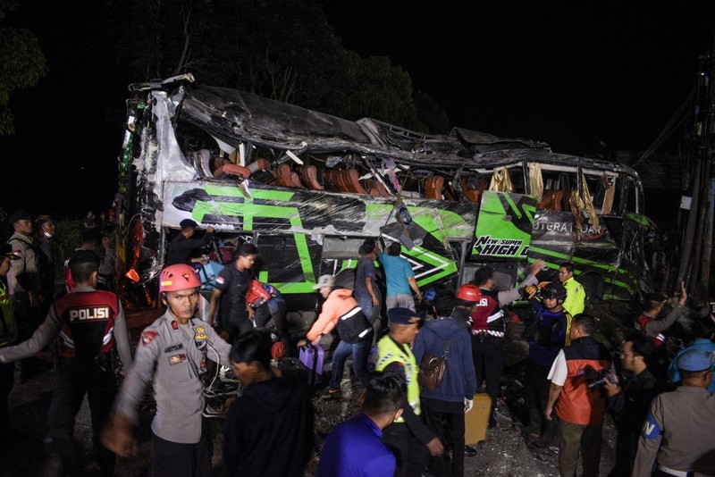 INDONESIA-ACCIDENT-BUS Officers check the debris and belongings of passengers after a bus crash that killed 11 people, according to local police, in Subang, West Java, on May 11, 2024. (Photo by Timur MATAHARI / AFP)