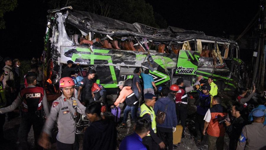 Officers check the debris and belongings of passengers after a bus crash that killed 11 people, according to local police, in Subang, West Java, on May 11, 2024. (Photo by Timur MATAHARI / AFP)