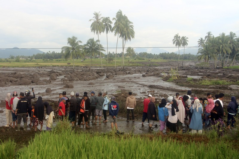 Indonesia Flash Floods People inspect an area affected by flash flood in Agam, West Sumatra, Indonesia, Sunday, May 12, 2024. Heavy rains and torrents of cold lava and mud rushing down a volcano on Indonesia’s Sumatra island have triggered flash floods that killed more than a dozen of people and injured several others, officials said Sunday. (AP Photo/Ali Nayaka)