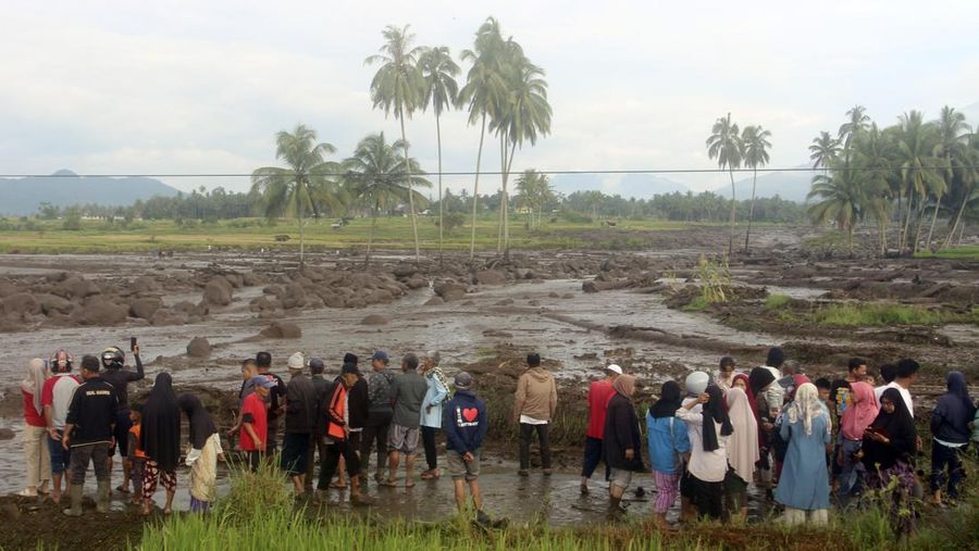 People inspect an area affected by flash flood in Agam, West Sumatra, Indonesia, Sunday, May 12, 2024. Heavy rains and torrents of cold lava and mud rushing down a volcano on Indonesia’s Sumatra island have triggered flash floods that killed more than a dozen of people and injured several others, officials said Sunday.  (AP Photo/Ali Nayaka)