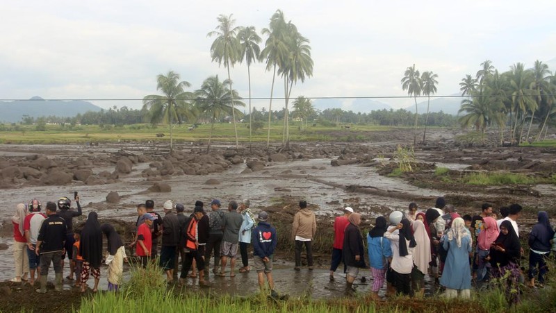 People inspect an area affected by flash flood in Agam, West Sumatra, Indonesia, Sunday, May 12, 2024. Heavy rains and torrents of cold lava and mud rushing down a volcano on Indonesia’s Sumatra island have triggered flash floods that killed more than a dozen of people and injured several others, officials said Sunday.  (AP Photo/Ali Nayaka)