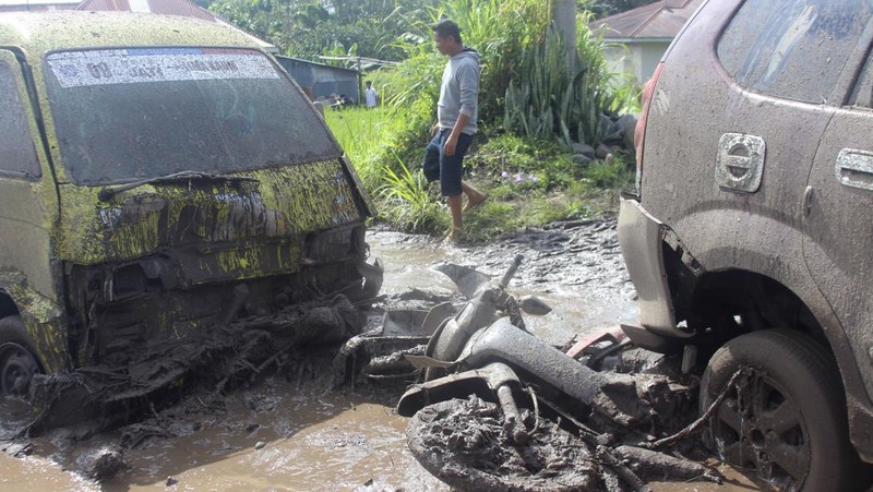 People inspect an area affected by flash flood in Agam, West Sumatra, Indonesia, Sunday, May 12, 2024. Heavy rains and torrents of cold lava and mud rushing down a volcano on Indonesia’s Sumatra island have triggered flash floods that killed more than a dozen of people and injured several others, officials said Sunday.  (AP Photo/Ali Nayaka)