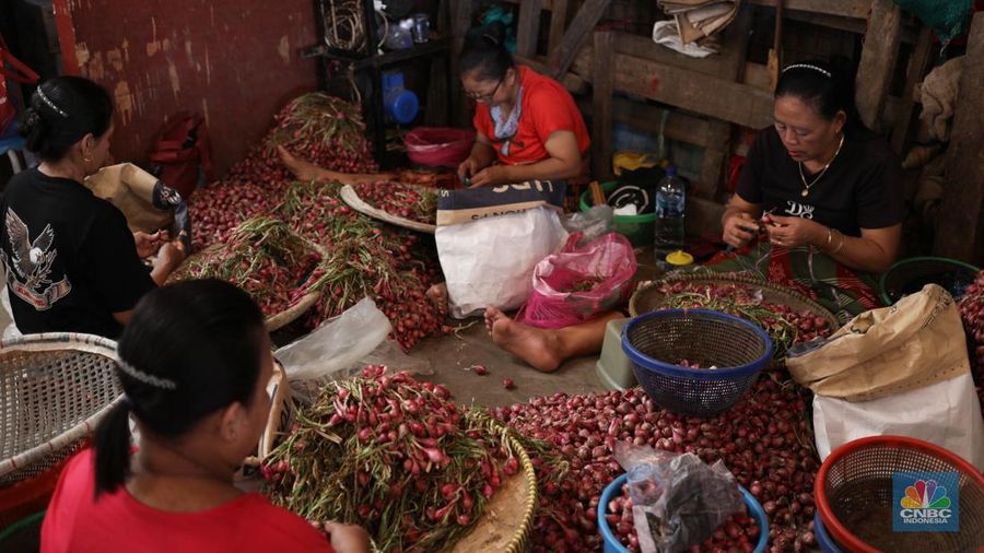 Pekerja membersihkan bawang merah yang baru tiba dari Brebes, di Pasar Induk, Kramat Jati, Jakarta Senin (13/5/2024). (CNBC Indonesia/Tri Susilo)