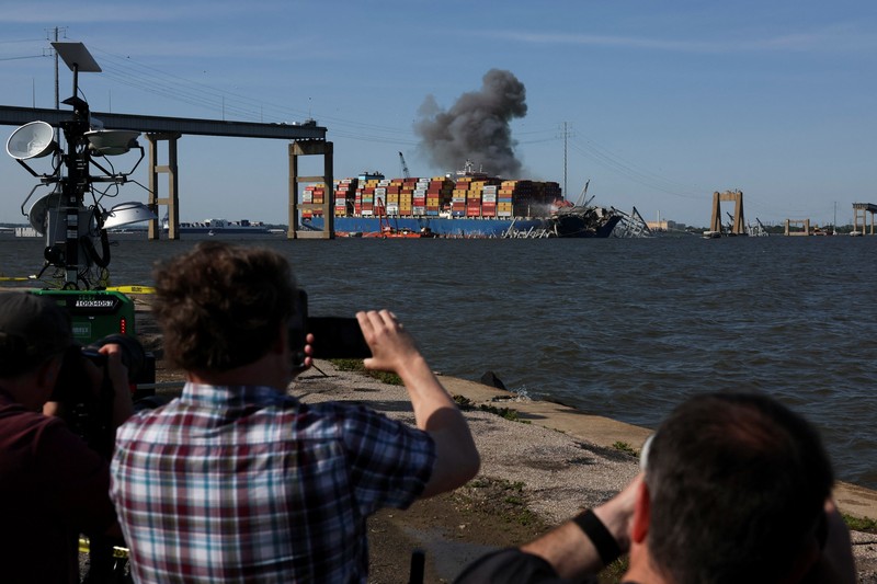 Pihak berwenang AS mulai mulai membongkar bagian jembatan Baltimore yang runtuh karena dihantam kapal kontainer Deli sekaligus mengevakuasinya lantaran telah terjabak sejak Maret lalu pada Senin (13/5/2024). (AP/Mark Schiefelbein) Pihak berwenang AS mulai mulai membongkar bagian jembatan Baltimore yang runtuh karena dihantam kapal kontainer Deli sekaligus mengevakuasinya lantaran telah terjabak sejak Maret lalu pada Senin (13/5/2024). (AP/Mark Schiefelbein)