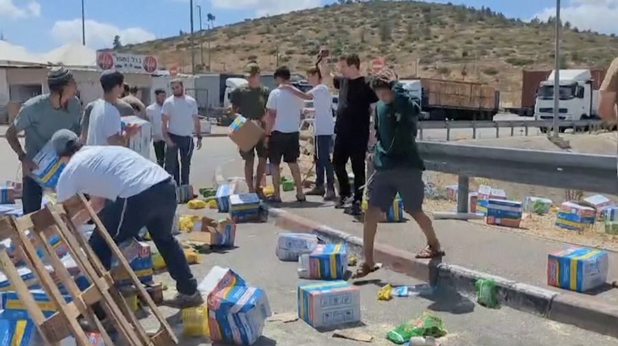 Sejumlah warga Israel memblokir truk bantuan yang menuju Gaza dan merusak serta menginjak paket makanan yang dibawa pada Senin (13/5/2024). Dari kemasannya, terlihat bahwa paket makanan tersebut termasuk produk seperti Indomie yang dikirim ke Gaza. (Tangkapan Layar Video Reuters/KAN2COME)
