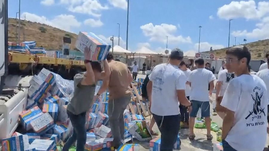 Sejumlah warga Israel memblokir truk bantuan yang menuju Gaza dan merusak serta menginjak paket makanan yang dibawa pada Senin (13/5/2024). Dari kemasannya, terlihat bahwa paket makanan tersebut termasuk produk seperti Indomie yang dikirim ke Gaza. (Tangkapan Layar Video Reuters/KAN2COME)