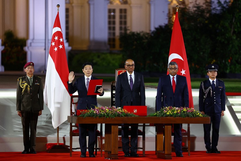 Wakil Perdana Menteri dan Menteri Keuangan Singapura Lawrence Wong, Presiden Singapura Tharman Shanmugaratnam dan Ketua Hakim Sundaresh Menon berdiri, saat Wong dilantik sebagai Perdana Menteri keempat Singapura di Istana, di Singapura, 15 Mei 2024. (REUTERS/Edgar Su/Pool)