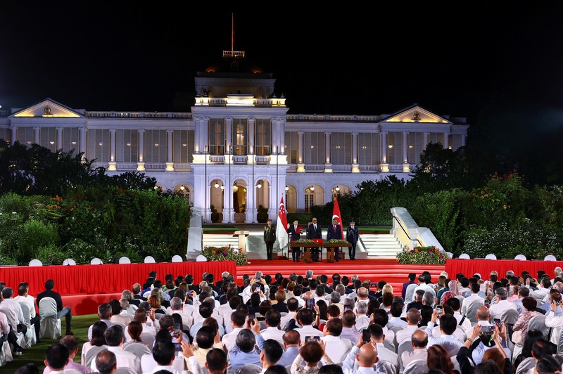 Wakil Perdana Menteri dan Menteri Keuangan Singapura Lawrence Wong, Presiden Singapura Tharman Shanmugaratnam dan Ketua Hakim Sundaresh Menon berdiri, saat Wong dilantik sebagai Perdana Menteri keempat Singapura di Istana, di Singapura, 15 Mei 2024. (REUTERS/Edgar Su/Pool)