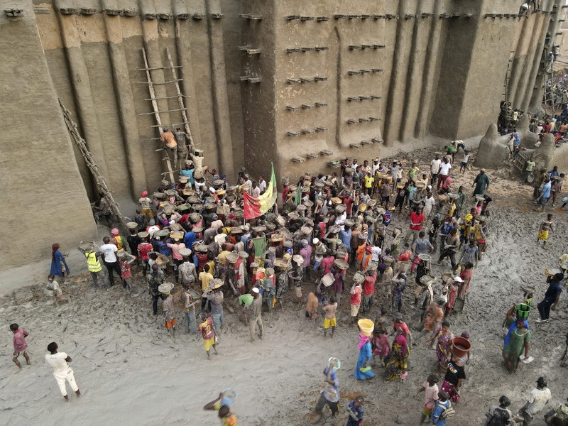 Warga Mali mengambil bagian dalam pekerjaan plesteran ulang tahunan bangunan bata lumpur terbesar di dunia, Masjid Agung Djenne, Mali, Minggu, 12 Mei 2024. Bangunan tersebut masuk dalam daftar Warisan Dunia dalam Bahaya UNESCO sejak 2016. Masjid dan kota sekitarnya terancam oleh konflik. Masjid Djenne memerlukan lapisan lumpur baru setiap tahun sebelum dimulainya musim hujan di bulan Juni. (AP Photo/Moustapha Diallo)