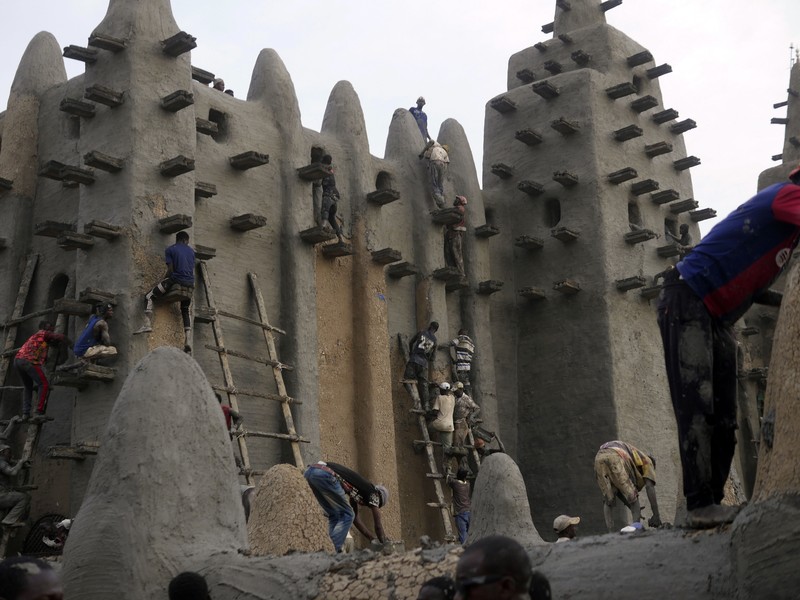 Warga Mali mengambil bagian dalam pekerjaan plesteran ulang tahunan bangunan bata lumpur terbesar di dunia, Masjid Agung Djenne, Mali, Minggu, 12 Mei 2024. Bangunan tersebut masuk dalam daftar Warisan Dunia dalam Bahaya UNESCO sejak 2016. Masjid dan kota sekitarnya terancam oleh konflik. Masjid Djenne memerlukan lapisan lumpur baru setiap tahun sebelum dimulainya musim hujan di bulan Juni. (AP Photo/Moustapha Diallo)