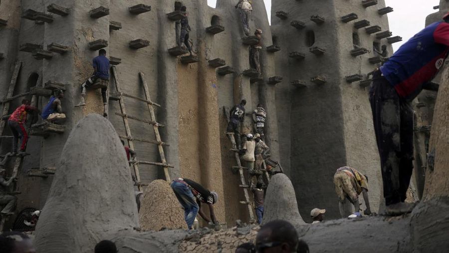 Warga Mali mengambil bagian dalam pekerjaan plesteran ulang tahunan bangunan bata lumpur terbesar di dunia, Masjid Agung Djenne, Mali, Minggu, 12 Mei 2024. Bangunan tersebut masuk dalam daftar Warisan Dunia dalam Bahaya UNESCO sejak 2016. Masjid dan kota sekitarnya terancam oleh konflik. Masjid Djenne memerlukan lapisan lumpur baru setiap tahun sebelum dimulainya musim hujan di bulan Juni. (AP Photo/Moustapha Diallo)