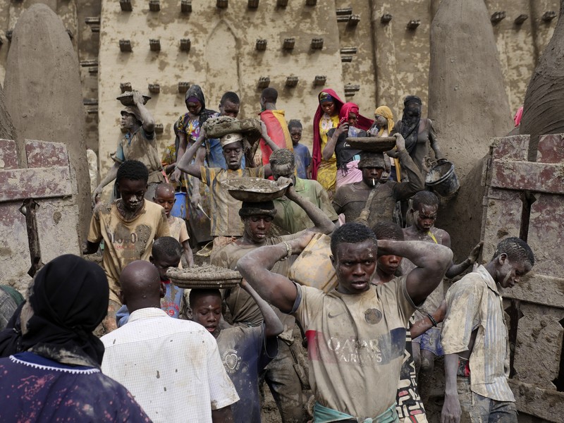 Warga Mali mengambil bagian dalam pekerjaan plesteran ulang tahunan bangunan bata lumpur terbesar di dunia, Masjid Agung Djenne, Mali, Minggu, 12 Mei 2024. Warga Mali mengambil bagian dalam pekerjaan plesteran ulang tahunan bangunan bata lumpur terbesar di dunia, Masjid Agung Djenne, Mali, Minggu, 12 Mei 2024. Bangunan tersebut masuk dalam daftar Warisan Dunia dalam Bahaya UNESCO sejak 2016. Masjid dan kota sekitarnya terancam oleh konflik. Masjid Djenne memerlukan lapisan lumpur baru setiap tahun sebelum dimulainya musim hujan di bulan Juni. (AP Photo/Moustapha Diallo)