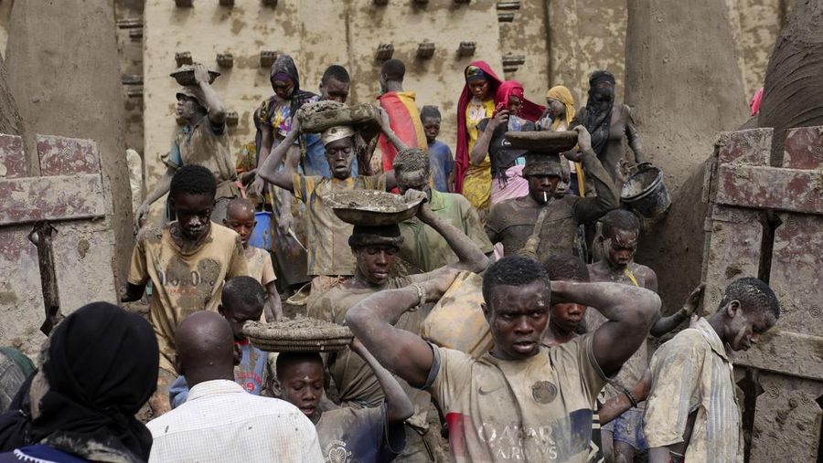 Warga Mali mengambil bagian dalam pekerjaan plesteran ulang tahunan bangunan bata lumpur terbesar di dunia, Masjid Agung Djenne, Mali, Minggu, 12 Mei 2024. Bangunan tersebut masuk dalam daftar Warisan Dunia dalam Bahaya UNESCO sejak 2016. Masjid dan kota sekitarnya terancam oleh konflik. Masjid Djenne memerlukan lapisan lumpur baru setiap tahun sebelum dimulainya musim hujan di bulan Juni. (AP Photo/Moustapha Diallo)