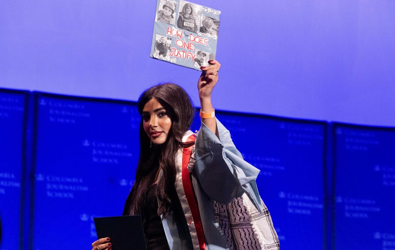 A student holds up her graduation hat with a message supporting her colleagues after receiving a diploma during a graduation ceremony at Columbia University Journalism School, during the ongoing conflict between Israel and the Palestinian Islamist group Hamas, in New York City, U.S., May 15, 2024.  REUTERS/Caitlin Ochs