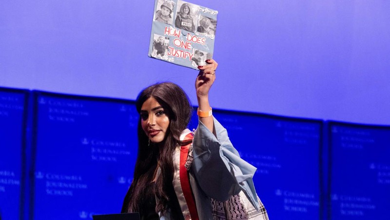 A student holds up her graduation hat with a message supporting her colleagues after receiving a diploma during a graduation ceremony at Columbia University Journalism School, during the ongoing conflict between Israel and the Palestinian Islamist group Hamas, in New York City, U.S., May 15, 2024.  REUTERS/Caitlin Ochs