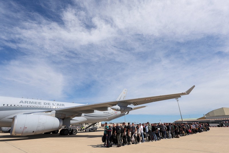 People line up as civil guards, police officers and sailors firefighters board a plane of the French Air Force at Istres military airbase after France declared a state of emergency to regain control of events in New Caledonia, near Marseille, France, May 16, 2024. REUTERS/Manon Cruz REFILE - CORRECTING FROM 