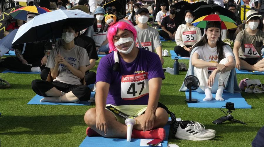 Participants take part in the Space-out Competition on a bridge in Seoul, South Korea, Sunday, Sept. 18, 2022. The competition is a performance art event that actively encourages exhausted city dwellers to do nothing and to free themselves from the stress of everyday life by rewarding the most zoned out. (AP Photo/Ahn Young-joon)