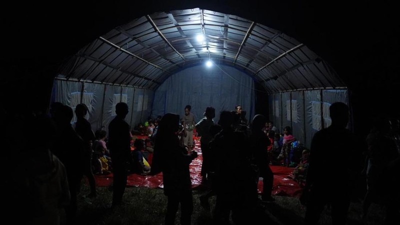 Babinsa membantu warga terdampak erupsi Gunungapi Ibu di Pos Pengungsian Desa Gam Ici, Kecamatan Ibu Tengah, Kabupaten Halmahera Barat, Maluku Utara, Sabtu (18/5/2024). (Dok. BNPB)