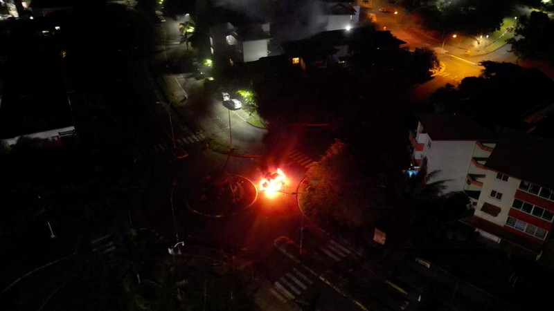 Pemandangan mobil-mobil yang terbakar di jalan, di tengah protes yang dipicu oleh kemarahan di kalangan penduduk asli Kanak atas amandemen konstitusi yang disetujui di Prancis yang akan mengubah siapa yang diizinkan untuk berpartisipasi dalam pemilu, yang dikhawatirkan oleh para pemimpin lokal akan melemahkan suara Kanak, di Noumea, New Kaledonia, 21 Mei 2024, dalam tangkapan layar ini diperoleh dari video media sosial. (Instagram @ericpaidjan/via REUTERS)