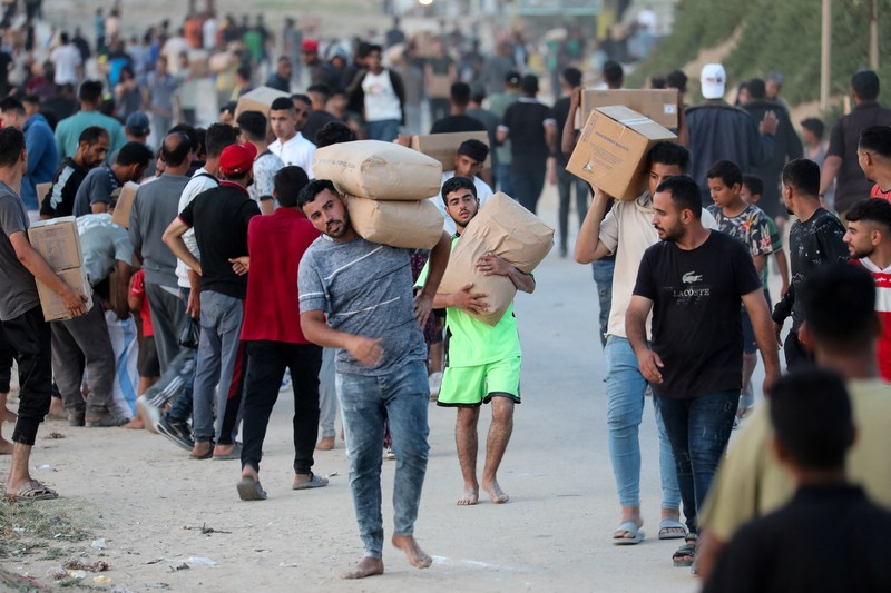 Warga Palestina menaiki truk untuk mengambil bantuan yang dikirim ke Gaza melalui dermaga buatan AS, di tengah konflik yang sedang berlangsung antara Israel dan kelompok Islam Palestina Hamas, terlihat dari pusat Jalur Gaza, 18 Mei 2024. Warga Palestina menaiki truk untuk mengambil bantuan yang dikirim ke Gaza melalui dermaga buatan AS, di tengah konflik yang sedang berlangsung antara Israel dan kelompok Islam Palestina Hamas, terlihat dari pusat Jalur Gaza, 18 Mei 2024. (REUTERS/Ramadan Abed)