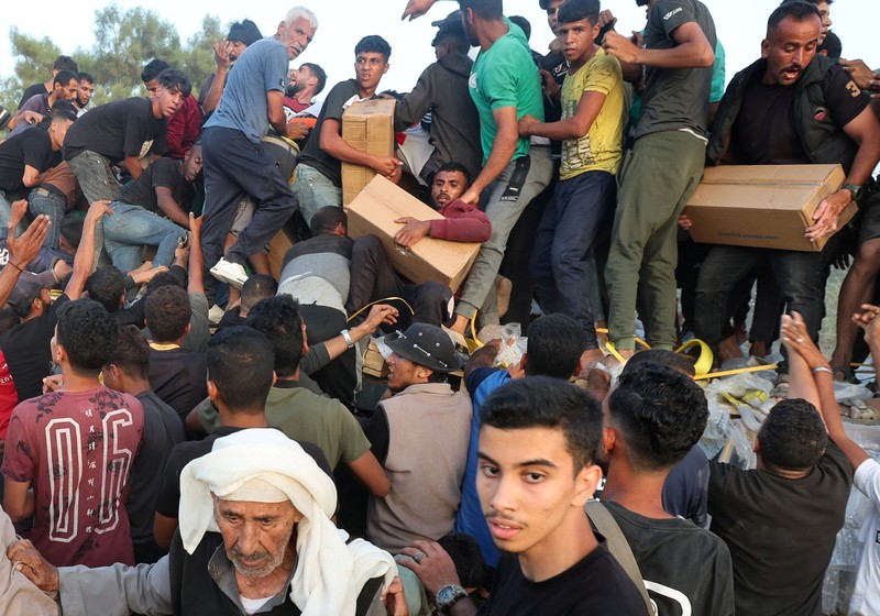 Warga Palestina menaiki truk untuk mengambil bantuan yang dikirim ke Gaza melalui dermaga buatan AS, di tengah konflik yang sedang berlangsung antara Israel dan kelompok Islam Palestina Hamas, terlihat dari pusat Jalur Gaza, 18 Mei 2024. Warga Palestina menaiki truk untuk mengambil bantuan yang dikirim ke Gaza melalui dermaga buatan AS, di tengah konflik yang sedang berlangsung antara Israel dan kelompok Islam Palestina Hamas, terlihat dari pusat Jalur Gaza, 18 Mei 2024. (REUTERS/Ramadan Abed)