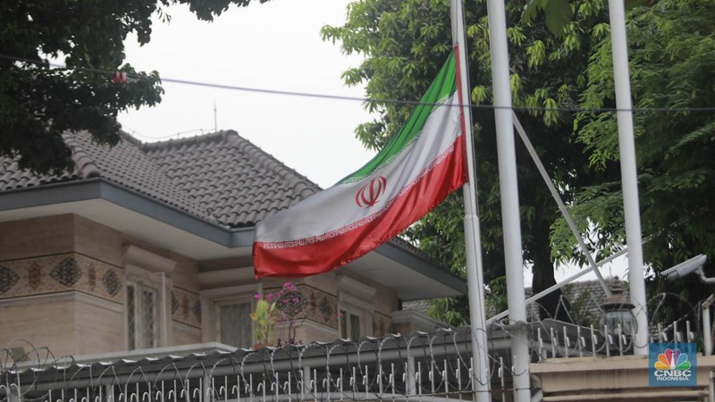 Warga melintas di depan Kedubes Iran, Jakarta, Senin, (20/5/2024). Kedutaan besar, konsulat jenderal dan kantor perwakilan Iran di Indonesia mengibarkan bendera setengah tiang. (CNBC Indonesia/Muhammad Sabki)