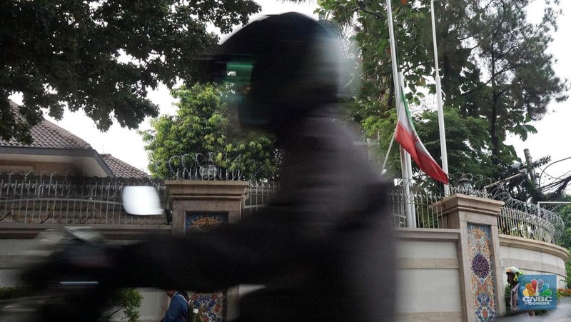 Warga melintas di depan Kedubes Iran, Jakarta, Senin, (20/5/2024). Kedutaan besar, konsulat jenderal dan kantor perwakilan Iran di Indonesia mengibarkan bendera setengah tiang. (CNBC Indonesia/Muhammad Sabki)