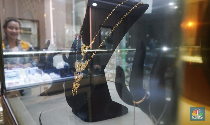 Karyawati menunjukkan emas PT Aneka Tambang Tbk. (Antam) di salah satu gallery penjualan emas di Jakarta, Selasa (21/5). (CNBC Indonesia/Muhammad Sabki)