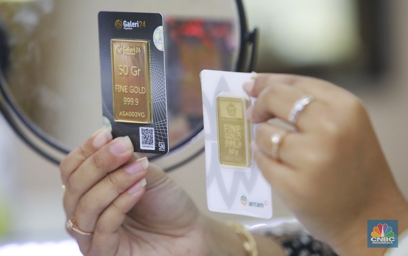 Karyawati menunjukkan emas PT Aneka Tambang Tbk. (Antam) di salah satu gallery penjualan emas di Jakarta, Selasa (21/5). (CNBC Indonesia/Muhammad Sabki)