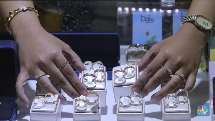 Karyawati menunjukkan emas PT Aneka Tambang Tbk. (Antam) di salah satu gallery penjualan emas di Jakarta, Selasa (21/5). (CNBC Indonesia/Muhammad Sabki)