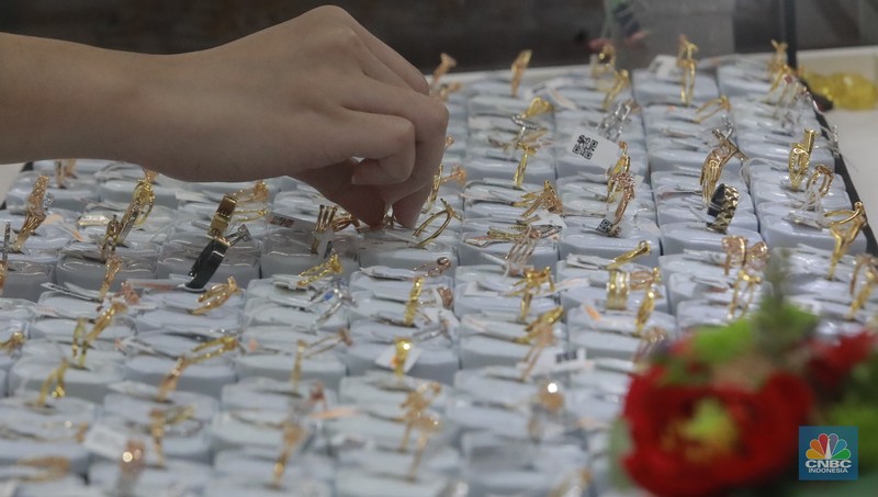 Karyawati menunjukkan emas PT Aneka Tambang Tbk. (Antam) di salah satu gallery penjualan emas di Jakarta, Selasa (21/5). (CNBC Indonesia/Muhammad Sabki)