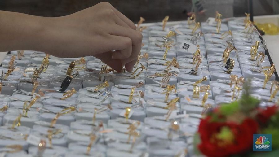 Karyawati menunjukkan emas PT Aneka Tambang Tbk. (Antam) di salah satu gallery penjualan emas di Jakarta, Selasa (21/5). (CNBC Indonesia/Muhammad Sabki)