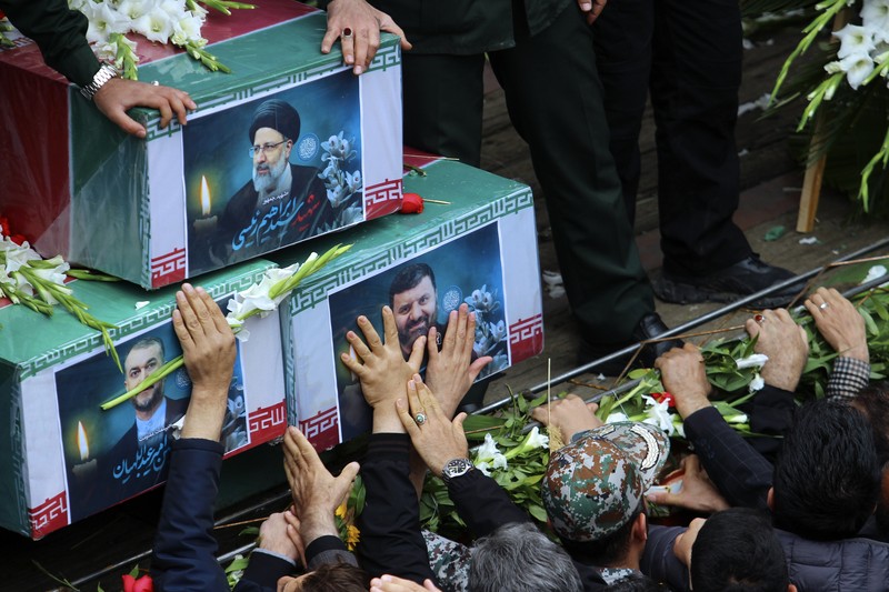 Warga Iran memberikan penghormatan terakhir saat jenazah mendiang Presiden Ebrahim Raisi diarak di jalana Tabr. (via REUTERS/Iran's Presidency/WANA)