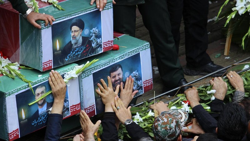 Warga Iran memberikan penghormatan terakhir saat jenazah mendiang Presiden Ebrahim Raisi diarak di jalana Tabr. (via REUTERS/Iran's Presidency/WANA)