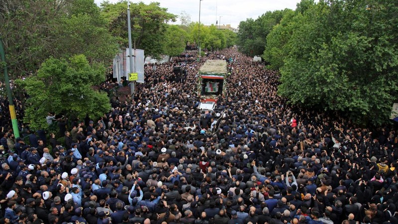 Warga Iran memberikan penghormatan terakhir saat jenazah mendiang Presiden Ebrahim Raisi diarak di jalana Tabr. (via REUTERS/Iran's Presidency/WANA)