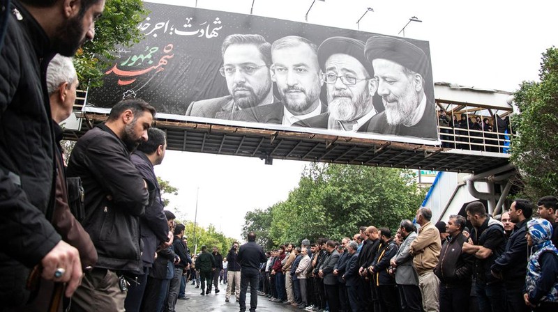 Warga Iran memberikan penghormatan terakhir saat jenazah mendiang Presiden Ebrahim Raisi diarak di jalana Tabr. (via REUTERS/Iran's Presidency/WANA)