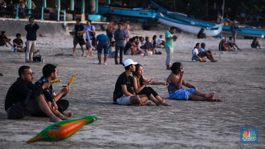 Wisatawan menikmati fenomena matahari tenggelam atau sunset di Pantai Muaya, Jimbaran, Bali, Selasa (21/5/2024). (CNBC Indonesia/Faisal Rahman)