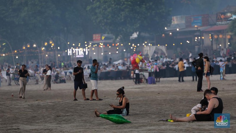 Wisatawan menikmati fenomena matahari tenggelam atau sunset di Pantai Muaya, Jimbaran, Bali, Selasa (21/5/2024). (CNBC Indonesia/Faisal Rahman)