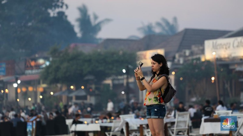 Wisatawan menikmati fenomena matahari tenggelam atau sunset di Pantai Muaya, Jimbaran, Bali, Selasa (21/5/2024). (CNBC Indonesia/Faisal Rahman)