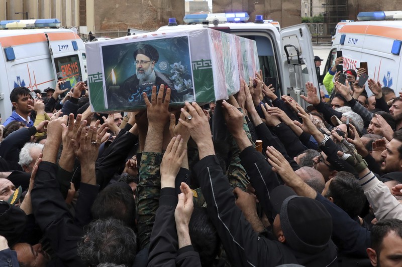 Warga Iran memberikan penghormatan terakhir saat jenazah mendiang Presiden Ebrahim Raisi diarak di jalana Tabr. (Ata Dadashi, Fars News Agency via AP)