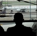 Orang-orang melihat pesawat Singapore Airlines penerbangan SQ321 yang diparkir di landasan setelah pendaratan darurat di Bandara Internasional Suvarnabhumi, di Bangkok, Thailand, 22 Mei 2024. (REUTERS/Athit Perawongmetha)