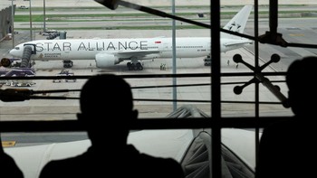 Orang-orang melihat pesawat Singapore Airlines penerbangan SQ321 yang diparkir di landasan setelah pendaratan darurat di Bandara Internasional Suvarnabhumi, di Bangkok, Thailand, 22 Mei 2024. (REUTERS/Athit Perawongmetha)