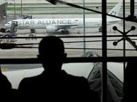 Orang-orang melihat pesawat Singapore Airlines penerbangan SQ321 yang diparkir di landasan setelah pendaratan darurat di Bandara Internasional Suvarnabhumi, di Bangkok, Thailand, 22 Mei 2024. (REUTERS/Athit Perawongmetha)