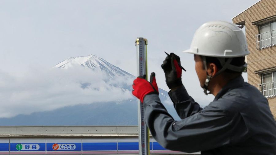 Para pekerja mendirikan barikade di dekat toko serba ada Lawson, tempat berfoto populer yang membingkai pemandangan indah dengan latar belakang Gunung Fuji di Fujikawaguchiko, Prefektur Yamanashi, Jepang tengah, Selasa (30/4/2024). (REUTERS/Kim Kyung-Hoon)