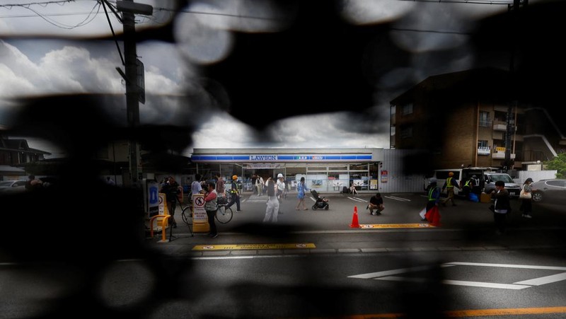Para pekerja mendirikan barikade di dekat toko serba ada Lawson, tempat berfoto populer yang membingkai pemandangan indah dengan latar belakang Gunung Fuji di Fujikawaguchiko, Prefektur Yamanashi, Jepang tengah, Selasa (30/4/2024). (REUTERS/Kim Kyung-Hoon)