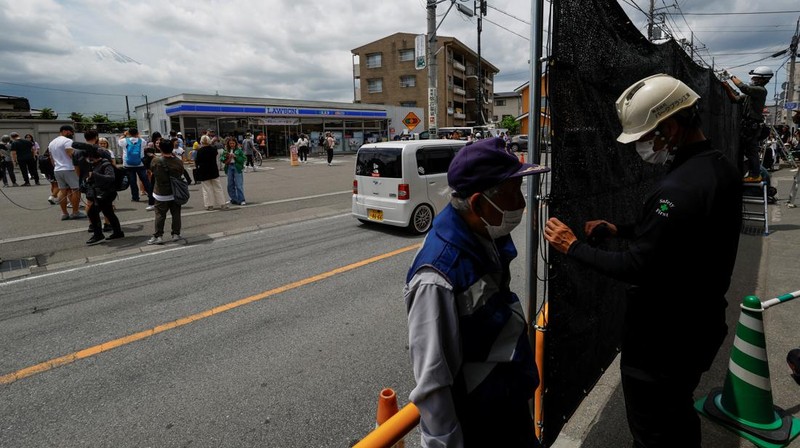 Para pekerja mendirikan barikade di dekat toko serba ada Lawson, tempat berfoto populer yang membingkai pemandangan indah dengan latar belakang Gunung Fuji di Fujikawaguchiko, Prefektur Yamanashi, Jepang tengah, Selasa (30/4/2024). (REUTERS/Kim Kyung-Hoon)