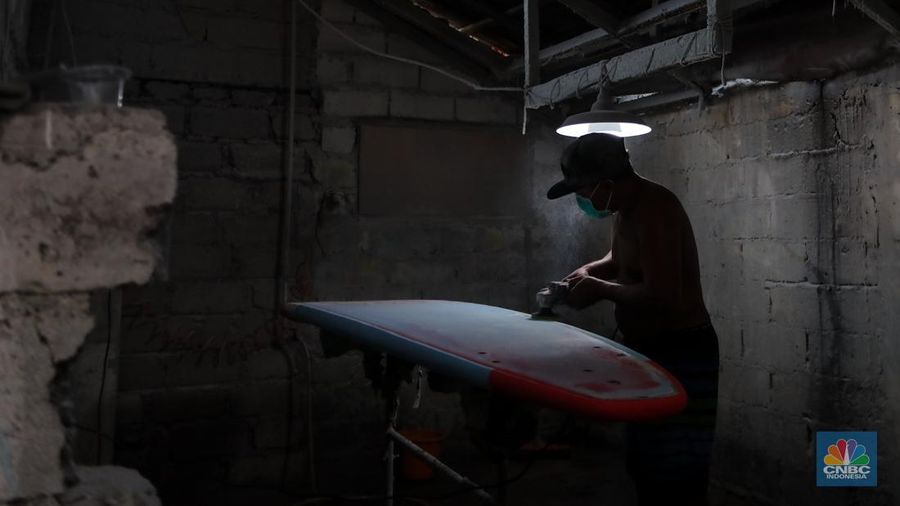Pekerja menyelesaikan proses pembuatan papan selancar (surfing) di Workshop Rezeki Selancar di kawasan Kuta, Badung, Bali, Rabu (22/5/2024). (CNBC Indonesia/Faisal Rahman)