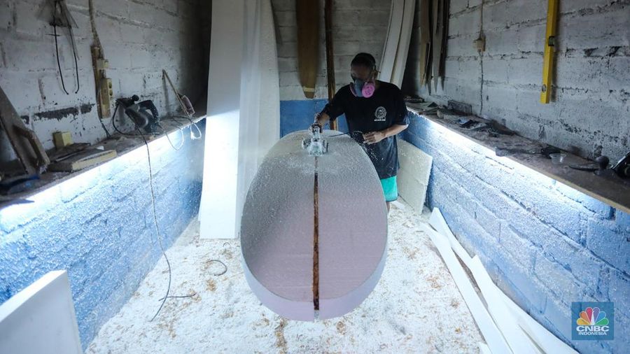 Pekerja menyelesaikan proses pembuatan papan selancar (surfing) di Workshop Rezeki Selancar di kawasan Kuta, Badung, Bali, Rabu (22/5/2024). (CNBC Indonesia/Faisal Rahman)