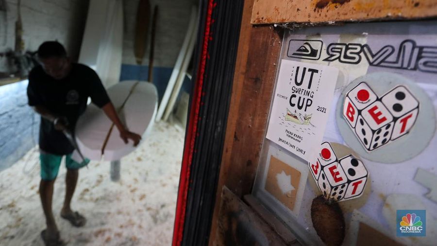 Pekerja menyelesaikan proses pembuatan papan selancar (surfing) di Workshop Rezeki Selancar di kawasan Kuta, Badung, Bali, Rabu (22/5/2024). (CNBC Indonesia/Faisal Rahman)