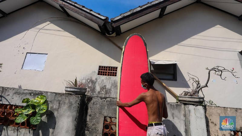 Pekerja menyelesaikan proses pembuatan papan selancar (surfing) di Workshop Rezeki Selancar di kawasan Kuta, Badung, Bali, Rabu (22/5/2024). (CNBC Indonesia/Faisal Rahman)